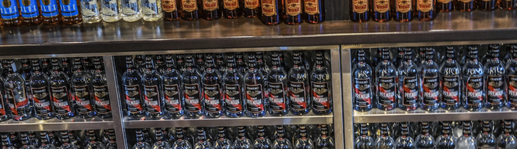 Glastender stainless steel shelving full of three types of liquors