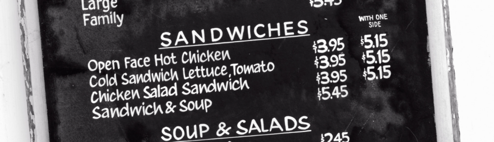 close up of a menu board showing prices for sandwiches and soups