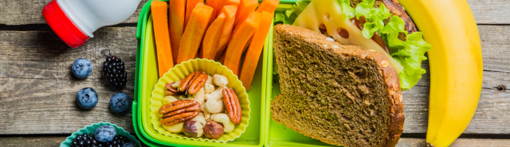 looking down on a school lunch tray with a sandwich and carrots