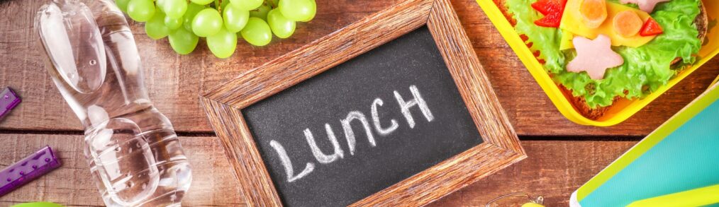 school lunch food on a table with a chalk board that reads LUNCH