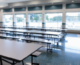 empty tables in a school cafeteria