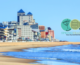 View of Ocean City, Maryland beaches. Buildings are in the background against a blue sky. Ocean City Trade Expo logo is in the upper left corner.